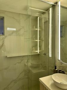 a bathroom with a glass shower and a sink at Refúgio Sofisticado Beira Mar in Florianópolis +21 photos