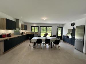 a large kitchen with a table and chairs in it at les resiniers in Moliets-et-Maa