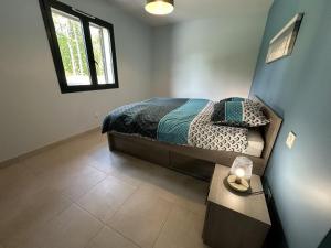 a bedroom with a bed and a table with a lamp at les resiniers in Moliets-et-Maa