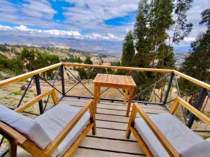a deck with chairs and a table on a balcony at Altipacha Valley Q Lodge in Quinua