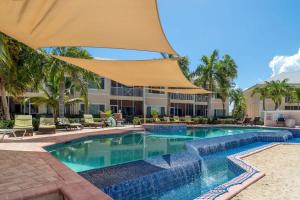 a swimming pool in a resort with an umbrella at Colonial Kai Condo in Driftwood Village