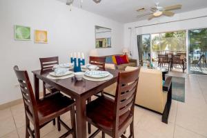 a dining room and living room with a table and chairs at Colonial Kai Condo in Driftwood Village