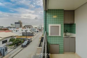 a green tiled balcony with a view of a city at Apto prox. do mar em Balneário Piçarras PDG0202 in Itajubá