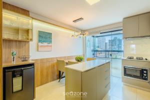 a kitchen with a counter and a dining room at Apto prox. do mar em Balneário Piçarras PDG0202 in Itajubá