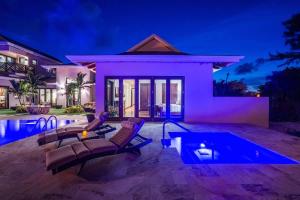a villa with a swimming pool at night at Stepping Stone 4 BR East End in Sand Bluff