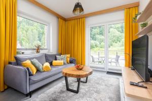 维斯瓦River Park Wisła - Golden Forest的客厅里有黄色的窗帘和灰色的沙发