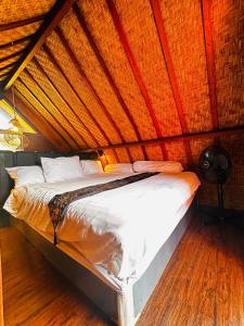 a bed in a room with a roof at Rustic Loft Bungalow in Jimbaran in Jimbaran