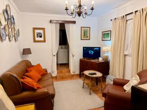 a living room with a couch and a tv at Casa da Tia Julia in Avis