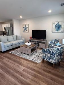 a living room with a couch and a tv at Chic Beach Home Near Airport Casino Base in Gulfport