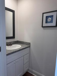 a bathroom with a sink and a mirror at Chic Beach Home Near Airport Casino Base in Gulfport
