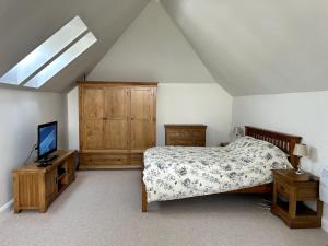 a bedroom with a bed and a television in it at Charming King Bed Ensuite Studio in Peaceful West Challow in Wantage
