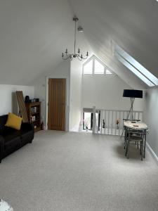 a living room with a couch and a table at Charming King Bed Ensuite Studio in Peaceful West Challow in Wantage