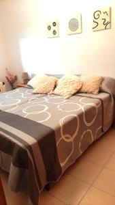 a large bed with a blanket on top of it at Apartamento Mediterráneo in Benicàssim +12 photos