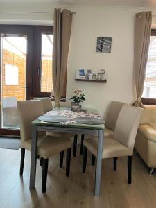 a dining table and chairs in a living room at Apartmán Losonci in Nesvady