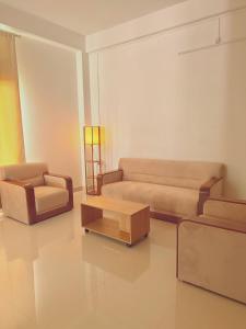 a living room with two couches and a coffee table at SAPPHIRE Homestay in Dibrugarh