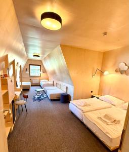 a hotel room with three beds and a desk at Horský hotel Brans in Malá Morávka +41 photos