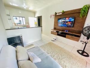 a living room with a couch and a flat screen tv at Casa 19 pessoas, piscina e jacuzzi in Nova Mutum