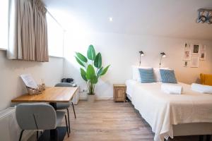 een slaapkamer met 2 bedden en een houten tafel bij Nassau Canal Suites - in the heart of the city in Amsterdam +24 foto's