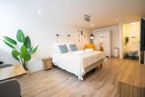 een slaapkamer met een groot wit bed met blauwe kussens bij Nassau Canal Suites - in the heart of the city in Amsterdam