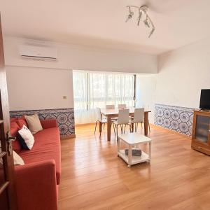 a living room with a red couch and a table at Sunny Marisol T2 in Aroeira