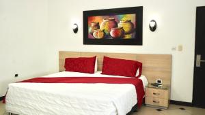 a bedroom with a bed with red pillows and a painting on the wall at Gran Hotel Internacional Sanbara in Arauca +96 photos