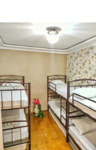 a room with three bunk beds and a vase of flowers at nizami m hostel in Baku