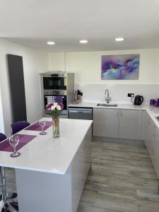 Una cocina con una encimera blanca con dos copas de vino. en Ulverstons little gem - Sleeps 2 - Free Parking, en Ulverston 9 fotos más