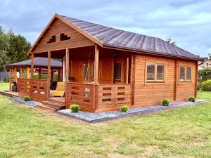 a large wooden cabin with a gambrel roof at Domek nad jeziorem in Izdebno