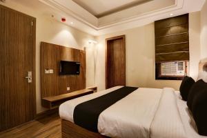 a bedroom with a large bed and a television at Super Collection O Stargaze in Kānpur