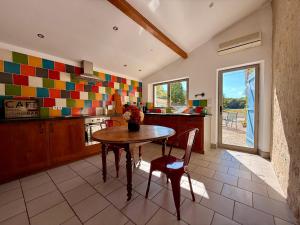 a kitchen with a table and chairs in a room at Gîte Le Patio Bleu in Saint-Romain