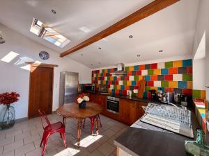 a kitchen with a table and chairs in a room at Gîte Le Patio Bleu in Saint-Romain