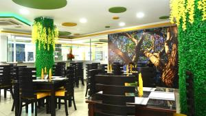 a restaurant with black tables and chairs and a green wall at Gran Hotel Internacional Sanbara in Arauca