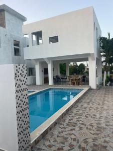 a villa with a swimming pool in front of a house at res Montesino in San Felipe de Puerto Plata