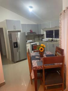 a kitchen with a table with a vase of flowers on it at res Montesino in San Felipe de Puerto Plata