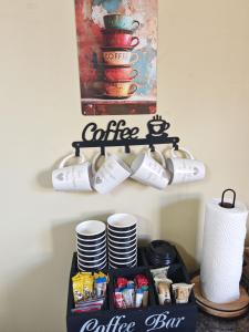 伯利恒Habakkuk Guesthouse的架子上摆放着杯子和盘子的咖啡吧