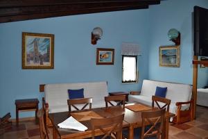 a living room with a couch and a table and chairs at Apartamentos Rurales Casa Ron in Coaña