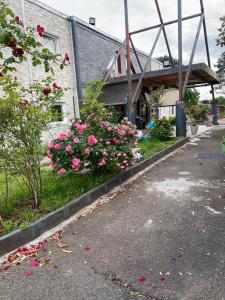 a house with pink flowers on the side of the road at N&Z HOTELS in Trappes