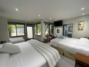 a large bedroom with two beds and a table at The Blue Eco Lodge in Valladolid