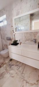 un bagno bianco con lavandino e WC di La Maison Piaf a Esposende Altre 22 foto
