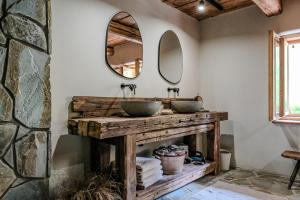 uma casa de banho com 2 lavatórios e uma parede de pedra em Chata Pytlorka Beskydy offgrid wellness em Zahŭří
