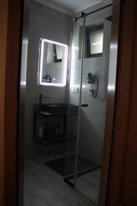 a bathroom with a glass shower and a sink at Király Apartments in Praid +5 photos