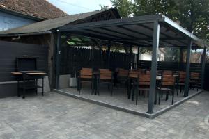 a pavilion with wooden tables and chairs and a television at Király Apartments in Praid