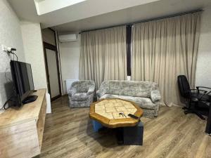 ein Wohnzimmer mit Sofa und Tisch in der Unterkunft Cozy Apartament in Rustavi in Rustawi