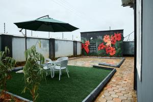 a patio with a table and chairs and an umbrella at Ay crib 