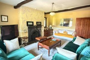 a living room with a couch and a fireplace at 4 Bed Retreat-Sleeps 7-Parking-Garden-Lake Views in Bolton