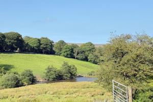 a field with a river in the middle at 4 Bed Retreat-Sleeps 7-Parking-Garden-Lake Views in Bolton