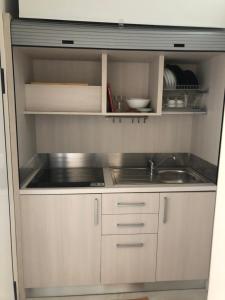 a small kitchen with white cabinets and a sink at Il fiore Blue in Barletta