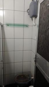 a bathroom with a toilet in a tiled room at Casa Sitio Junqueira in Mangaratiba