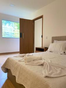 Un dormitorio con una cama grande con toallas. en Bik House Pousada e Festa, en Mimoso do Sul