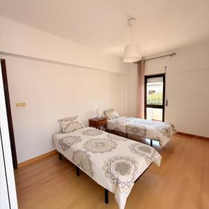 a room with two beds and a window at Sunny Marisol T2 in Aroeira